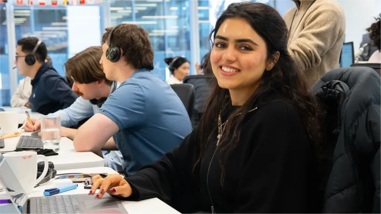One of our call centre employees smiles at the camera while she and her colleagues are at work.