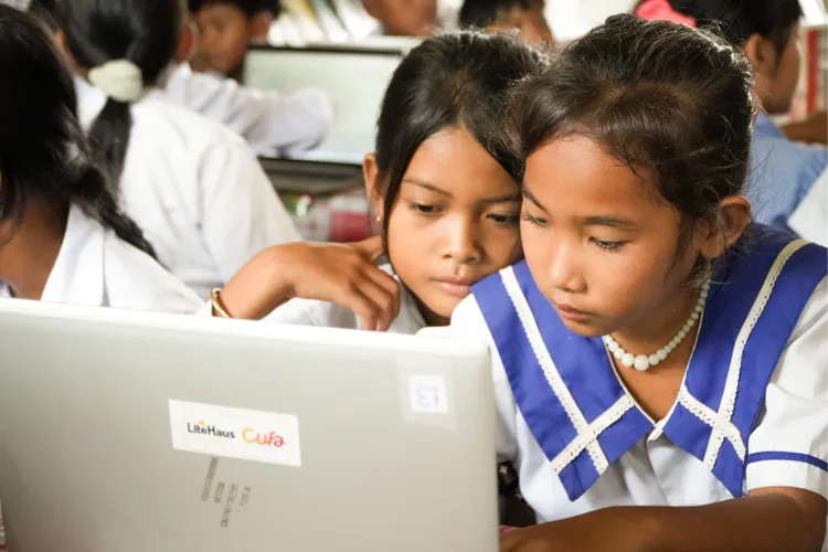Two Cambodian children study financial literacy thanks to CUFA.