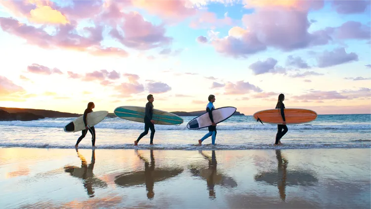 Surfers walking along the beach with surfboards
